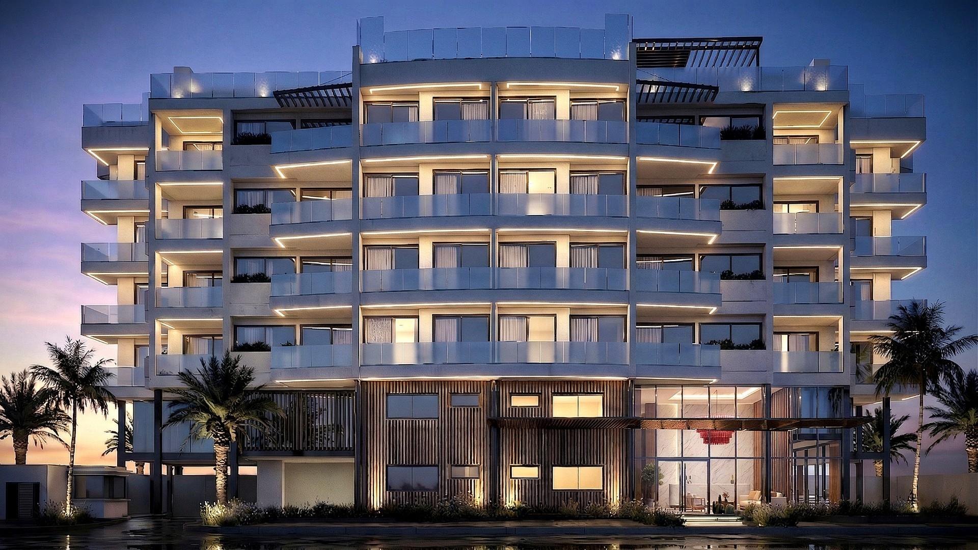 Dusk rendering of the lit YOO Aruba facade in Ponton, Oranjestad: 26 residences over five residential levels, not yet built, with completion stated as Q4 2027.