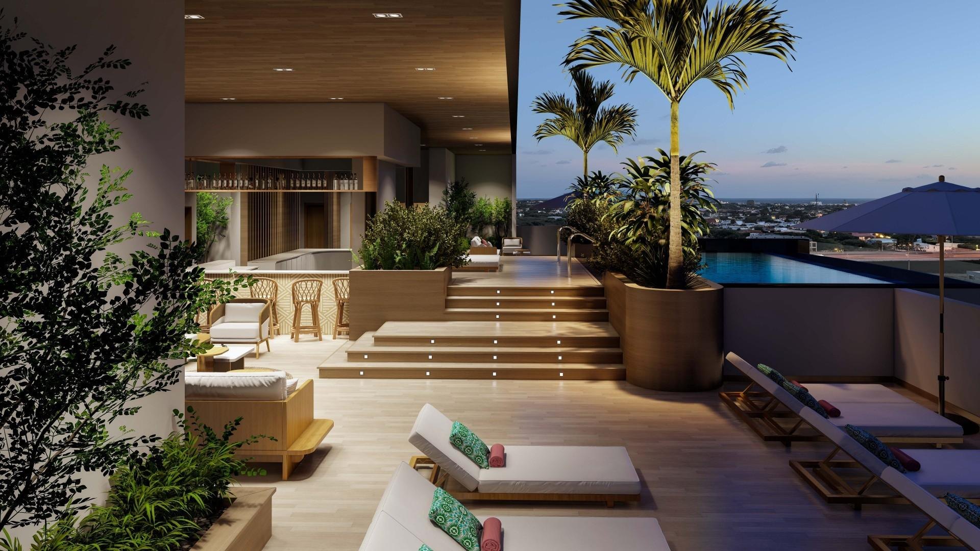 Rendering of YOO Aruba's rooftop terrace at dusk, its bar and loungers above the town and sea horizon; the building's 26 residences are due in Q4 2027.